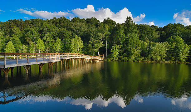 A bridge crosses a lake in the Appalachian mountains with vivid colors reflected in the water.