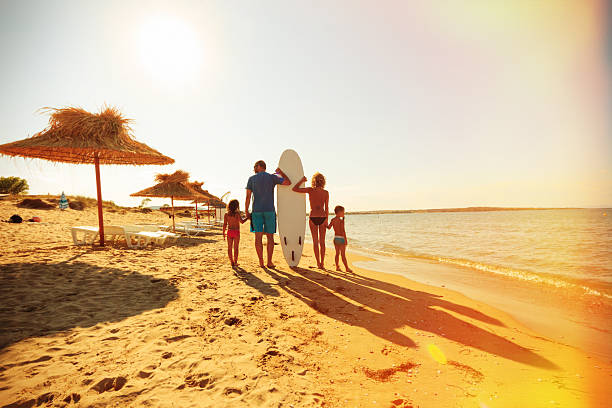 famiglia sulla spiaggia - surfing beach family father foto e immagini stock