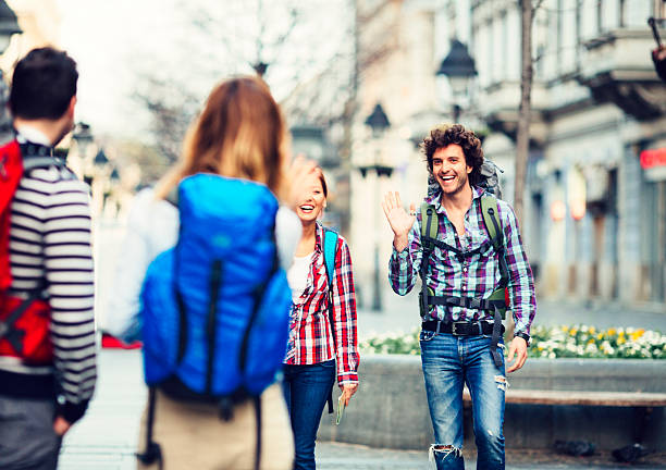 Cheerful young backpackers enjoy their visit to new city. Meeting with another couple. Belgrade, Serbia, Knez Mihailova Street