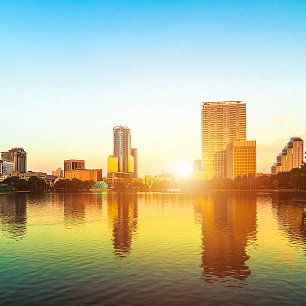 lever du soleil à orlando, lac eola, lumière du soleil évasé - eola park photos et images de collection