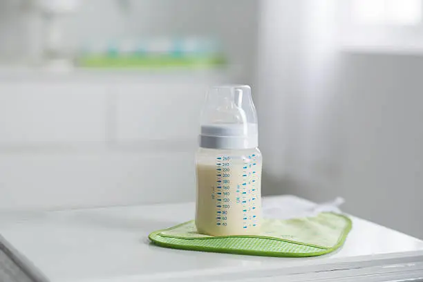 plastic baby bottle in white bedroom