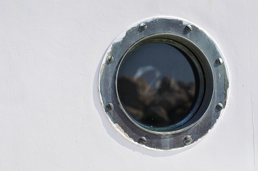 Porthole in the white hull of passenger ship. Marine  background