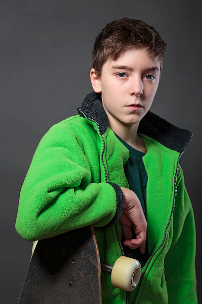 istock teenage boy with long board and gray background 482549846