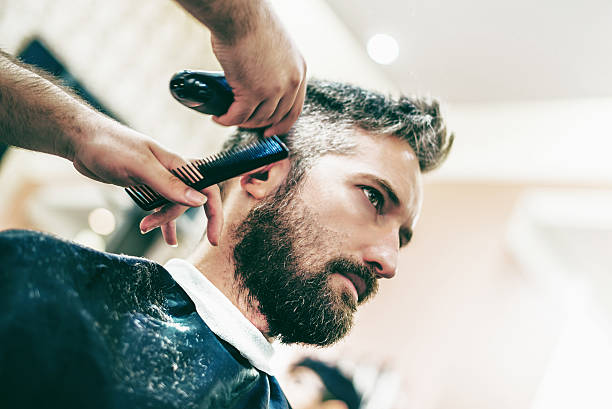 istock bearded grey haired man getting hair cut in barber shop 482551086
