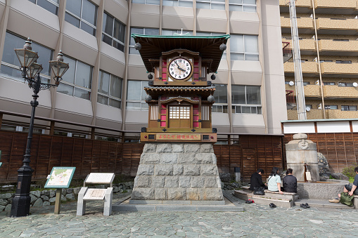 Matsuyama, Japan - April 13, 2015: People at the Botchan Karakuri Clock in Dogo Onsen, Matsuyama, Ehime Prefecture, Shikoku, Japan. Erected in the Hojoen Square in front of Dogo Onsen Station as part of Dogo Onsen Honkan's Centennial in 1994.