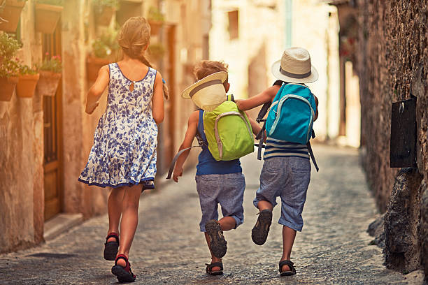 istock Kids running in mediterranean street. 482555130