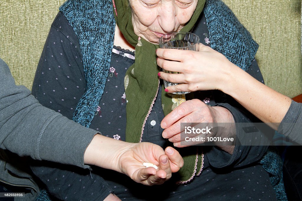 Krankenschwester, die Hand eines Patienten Medikamente und Wasser - Lizenzfrei Afrikanischer Abstammung Stock-Foto