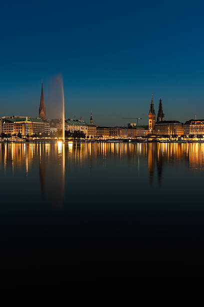 During blue hour view to Binnenalster with fountain in Hamburg,  Germany.