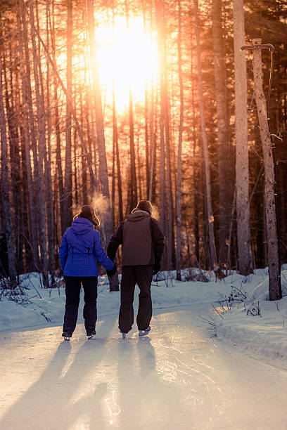 istock Happy Senior Couple Ice Skating Holding Hands at Sunset 482556490