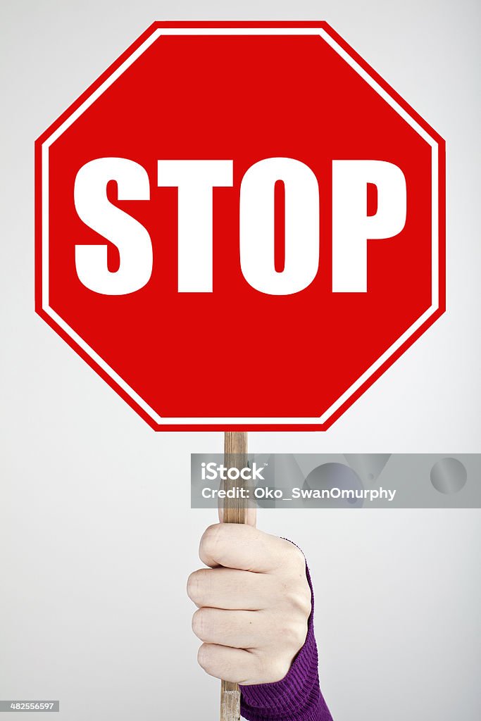 STOP SIGN Woman hand holding Stop sign - vertical Hand Raised Stock Photo