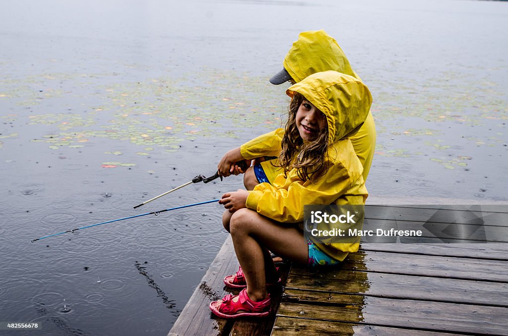 Garota e garoto pesca sob chuva - Foto de stock de Chuva royalty-free