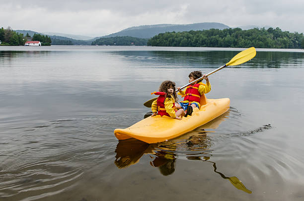 istock Young boy and girl kayaking on a lake 482556750