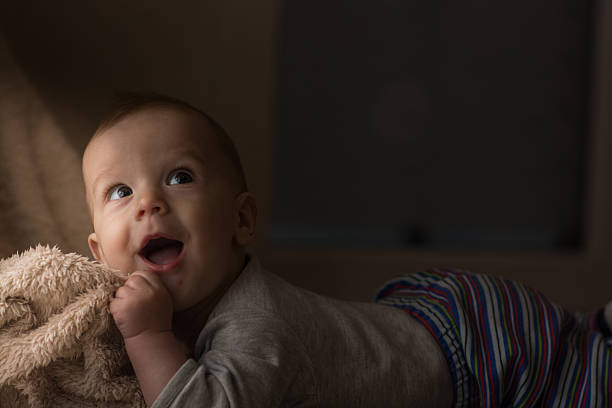 little baby lying on stomach, looking a way and enjoying