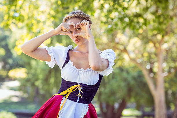 hübsche oktoberfest blonde lächelnde im park - oktoberfest stock-fotos und bilder