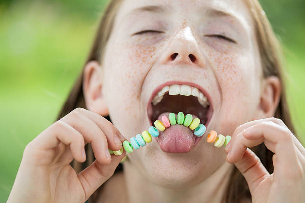 istock Freckled Litte Girl Enjoying a Candy Necklace 482557412