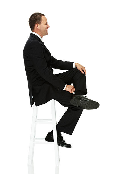 istock Side view of happy businessman sitting on stool 482557533