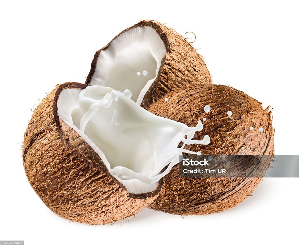 Coconut with milk splash on white background Coconut Milk Stock Photo
