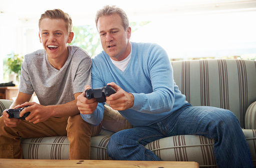 A father and his teenage son playing a playstation game togetehrhttp://195.154.178.81/DATA/istock_collage/0/shoots/784352.jpg