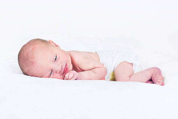 istock One day old newborn baby smiling while relaxing on tummy 482560265