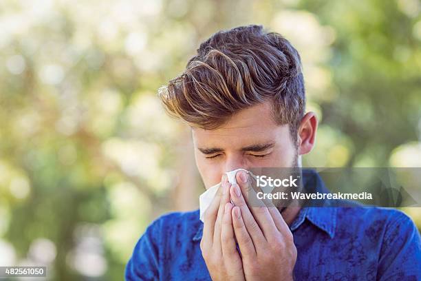 Handsome Hipster Blowing His Nose Stock Photo - Download Image Now - Men, Sneezing, Outdoors