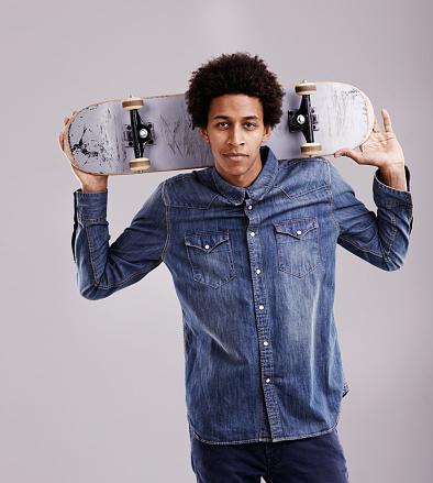 Studio shot of a fashionable young man posing with his skateboard behind his headhttp://195.154.178.81/DATA/i_collage/pu/shoots/805348.jpg