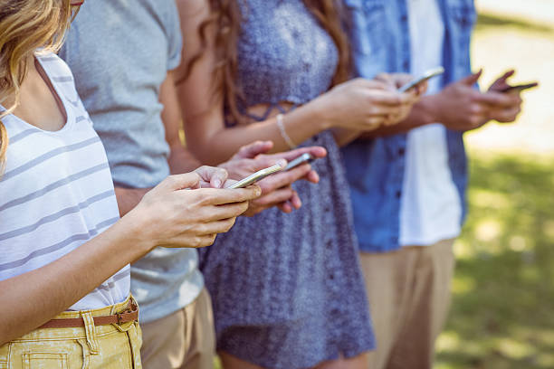 istock Happy friends in the park using their phones 482564260