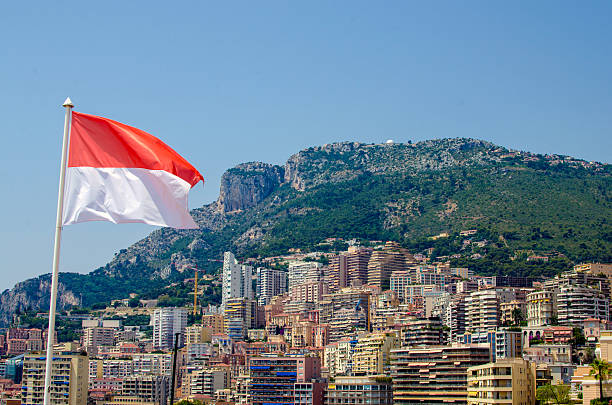 National flag of Monaco Monte Carlo town in background stock photo