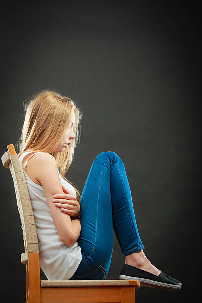 istock Young sad woman sitting on chair 482565784