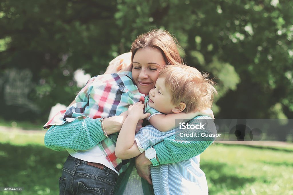 Family happiness! Happy mother tenderly embracing his two sons i Family happiness! Happy mother tenderly embracing his two sons in spring day, warm feelings of the mother, moment of life, happy family on nature Mother Stock Photo