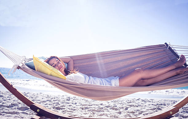 istock Pretty brunette relaxing with her straw hat in the hammock 482566162