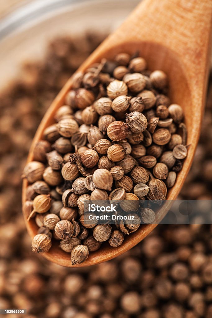 Corriander - cilantro Coriander seed in wooden teaspoon; extreme close up;  Bowl Stock Photo