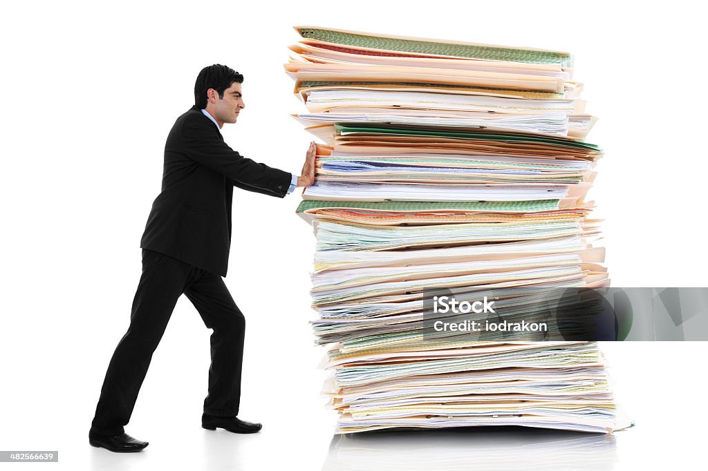 Paper Pusher Stock image of businessman pushing a giant stack of documents isolated on white background Lawsuit Stock Photo