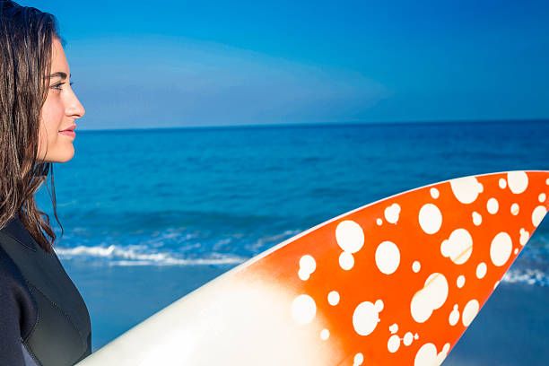 Carrying a wave board and running on the beach and towards the sea