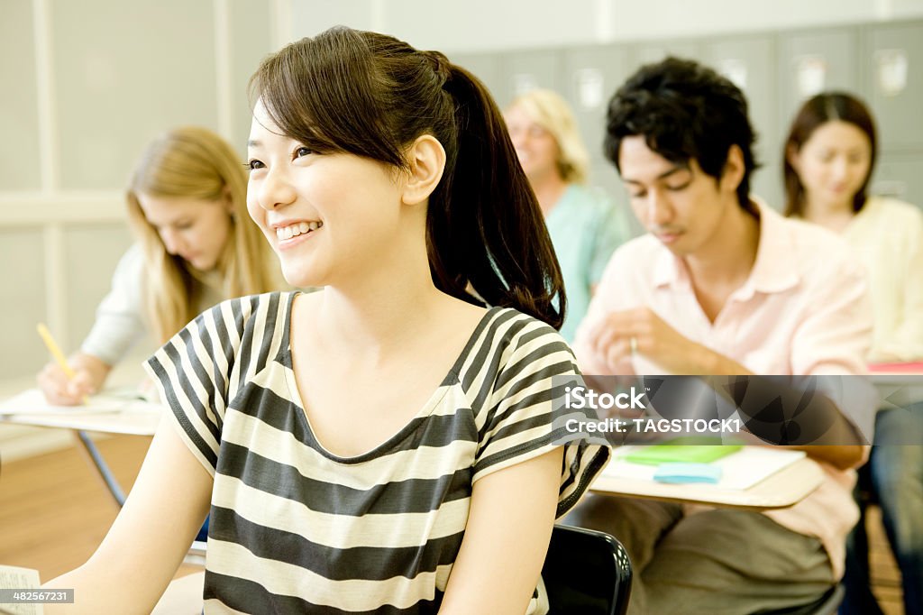 Lächelnde Studentin, die im Klassenzimmer studiert - Lizenzfrei Universitätsstudent Stock-Foto