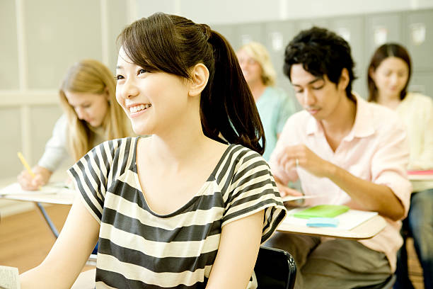 Smiling female student studying in classroom stock photo
