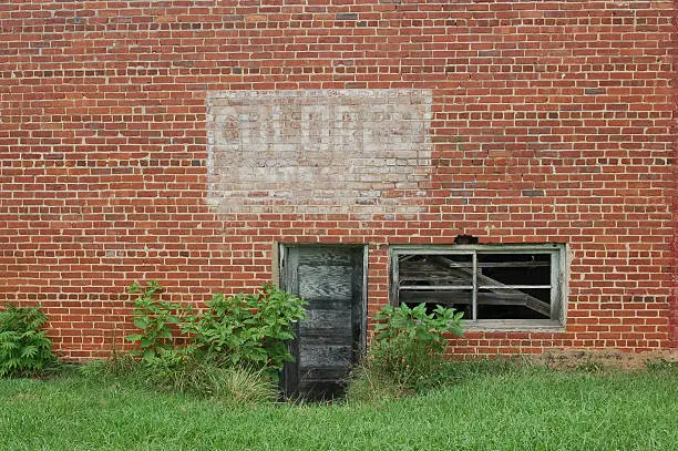 The side of this building shows a sign from the past stating Colored Entrance.  It was from a time where African Americans were not allowed to enter the same entrance as whites.