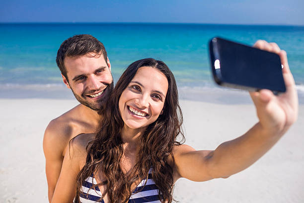 istock Happy couple taking a selfie at the beach 482573264