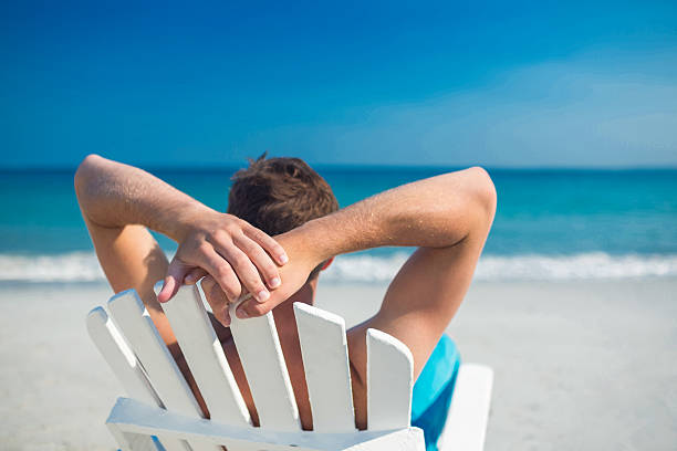 istock Man relaxing on deck chair at the beach 482576788
