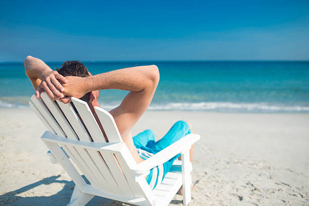 istock Man relaxing on deck chair at the beach 482576790