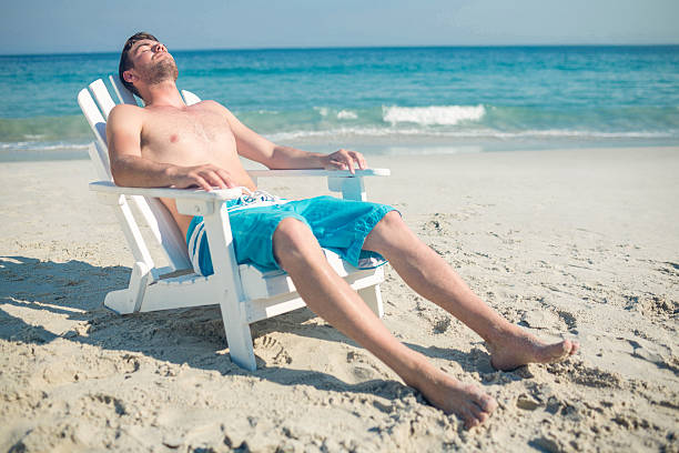 istock Man relaxing on deck chair at the beach 482576796