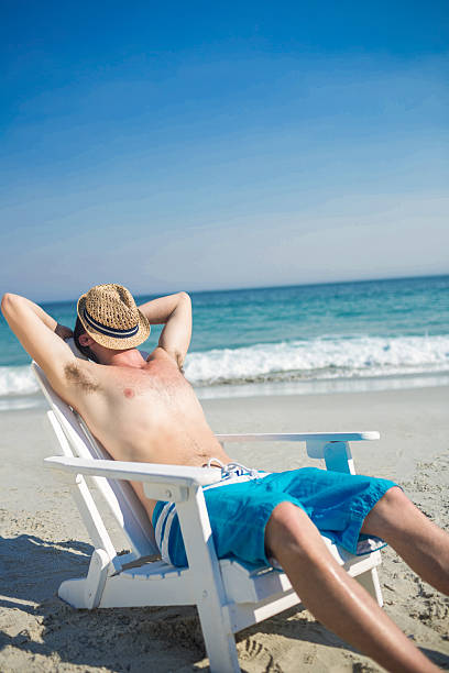 istock Man relaxing on deck chair at the beach 482576802