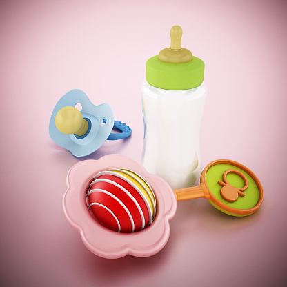 Pacifier, feeding bottle and rattle on pink surface.