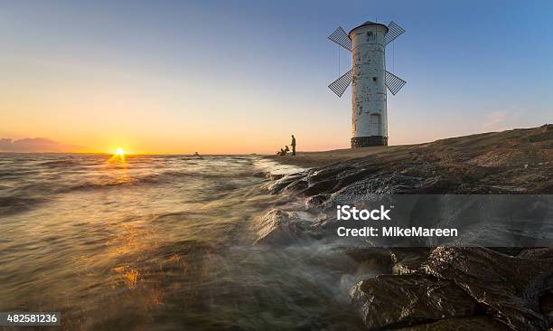 Sunset On The Coast Lighthouse Windmill In Swinoujscie Poland Stock Photo - Download Image Now