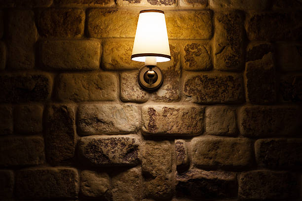 istock lamp shining on a wall made of stones 482581740
