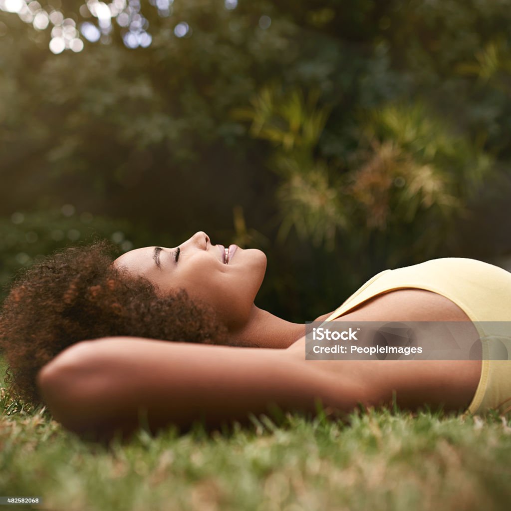 Relaxing on a golden afternoon... Shot of a relaxed young woman lying on the grass with her eyes closedhttp://195.154.178.81/DATA/i_collage/pi/shoots/783692.jpg Relaxation Stock Photo