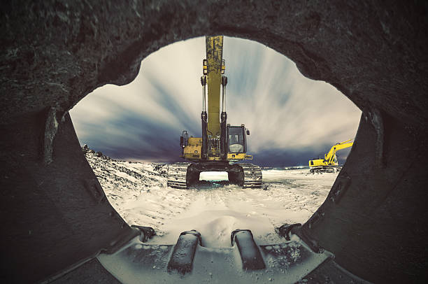 A 180 degree view from within the massive bucket of an excavator on a snowy construction site at night.  Long exposure, stitched images.