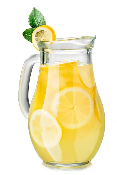 A jug of lemonade with lemon slices isolated on white