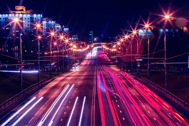 la circulation sur route de nuit illuminée en centre-ville - traffic blurred motion multiple lane highway night photos et images de collection