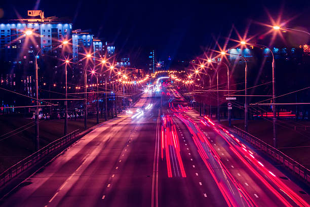 soir trafic et l'éclairage en soirée dans le big centre-ville - traffic blurred motion multiple lane highway night photos et images de collection