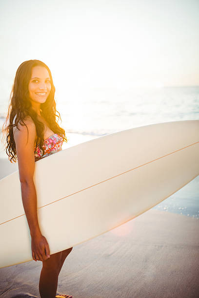 istock Pretty brunette with surfboard on sunny day 482586406